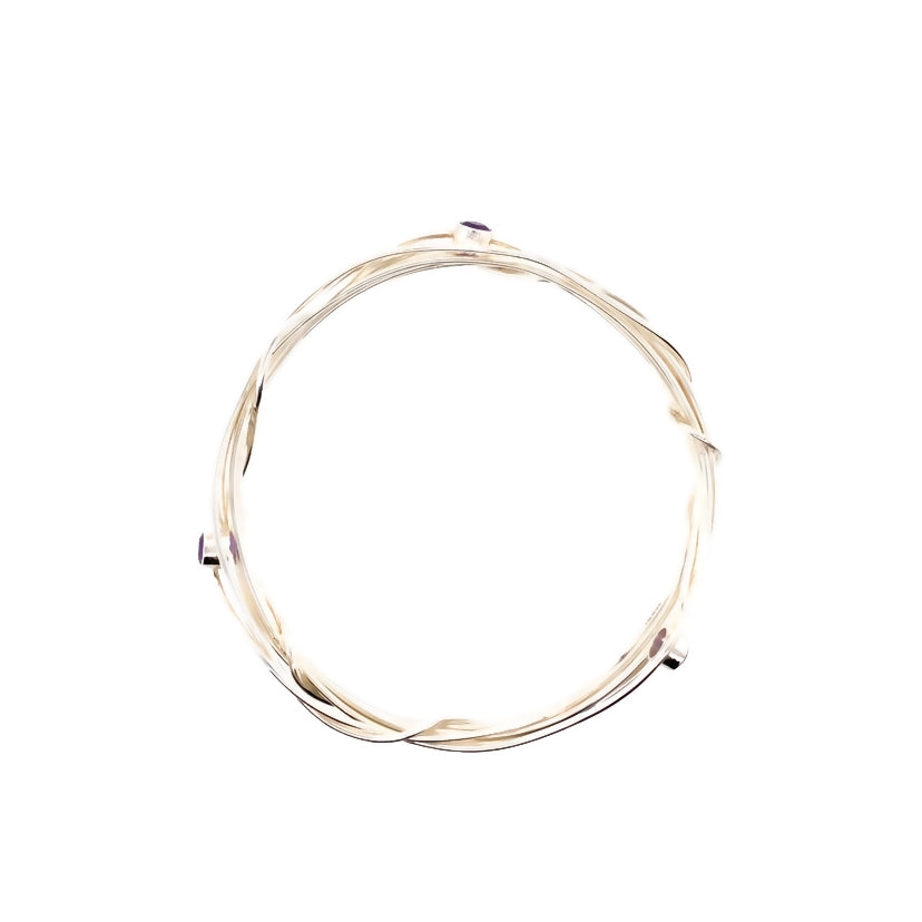 Three faceted amethyst stones set on a silver wrap bangle