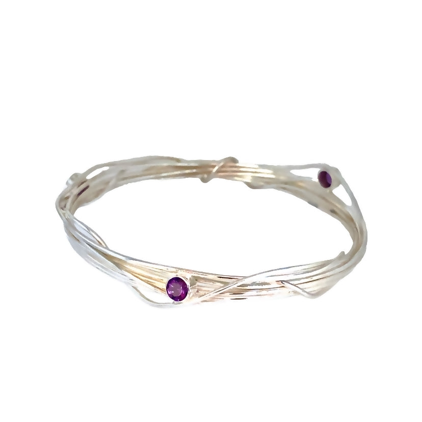 Three faceted amethyst stones set on a silver wrap bangle