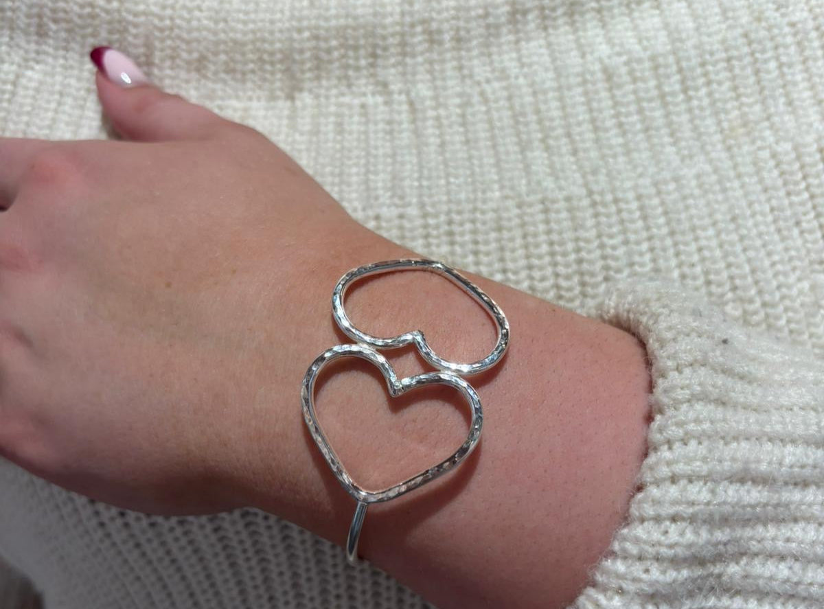 Polished silver oval bangle with two hammered heart