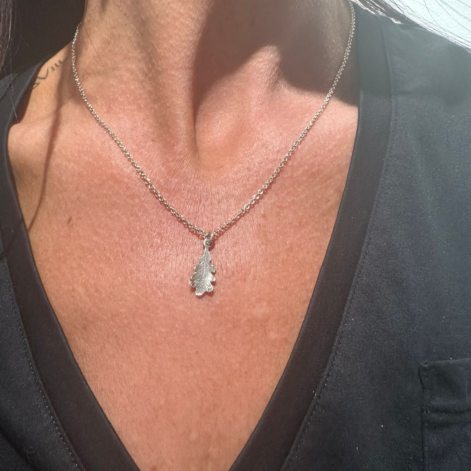 Necklace with a pendant worn by a person against a black background