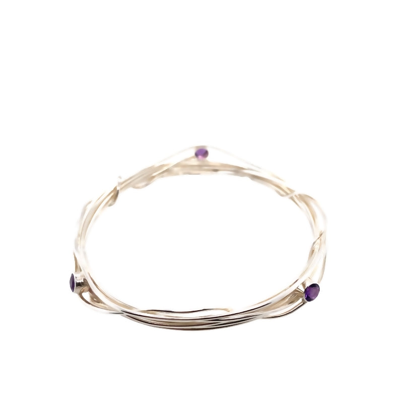 Three faceted amethyst stones set on a silver wrap bangle