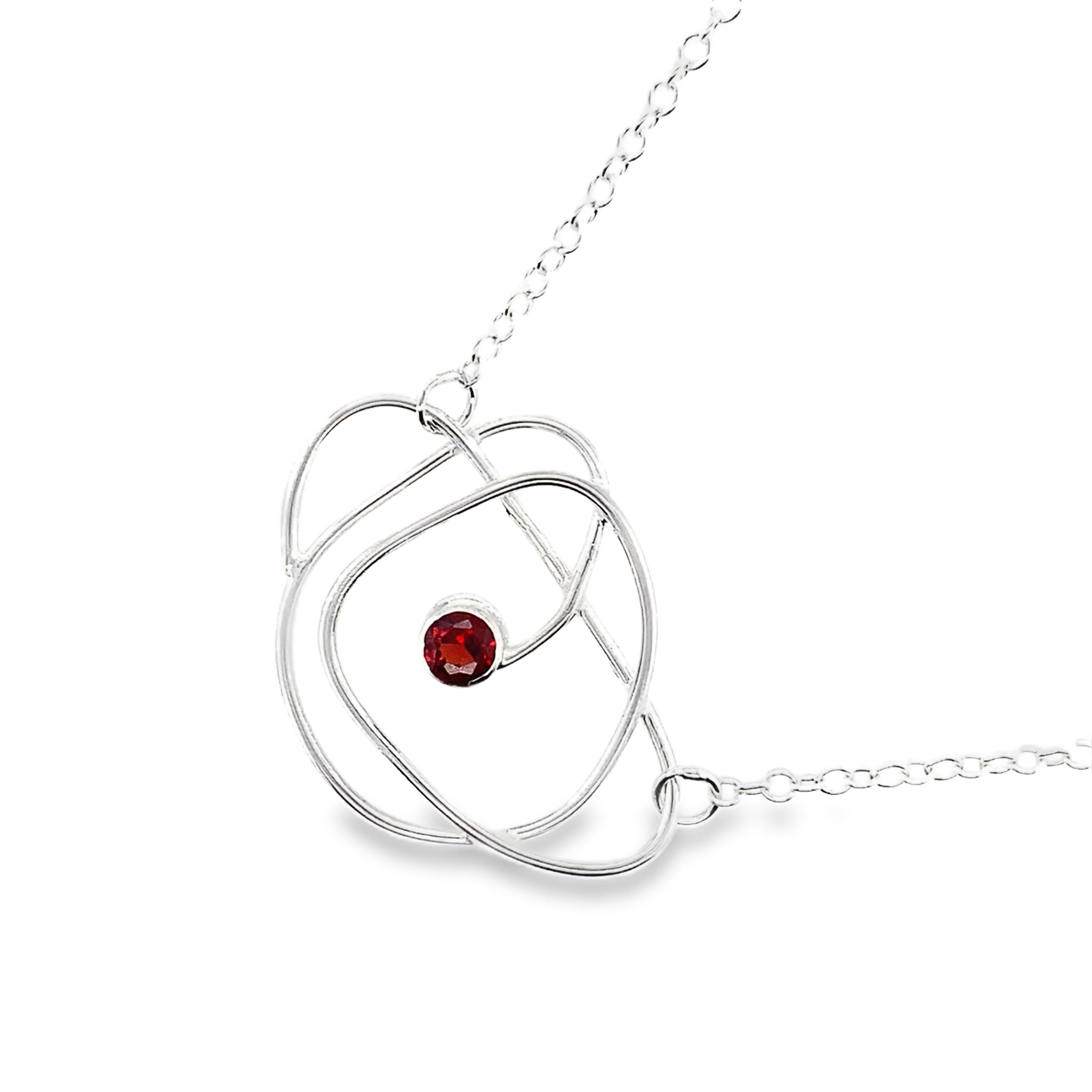Faceted red garnet stone set on a silver wrap necklace