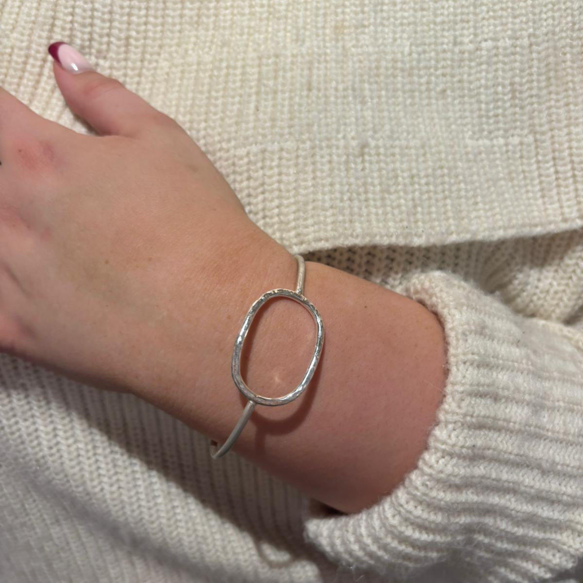 Silver oval bangle with a scratch matt finish